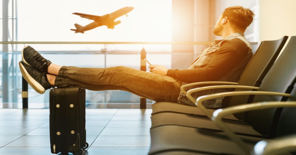 Man waiting for his flight in the airport following a negative Covid test result.