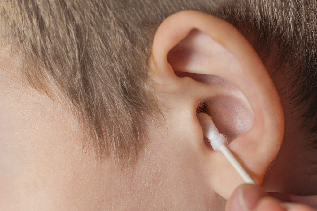 Cleaning the ear with a cotton swab.