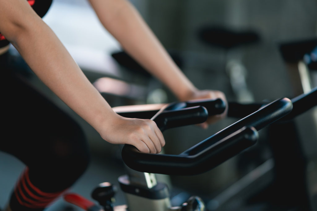 Crop Picture Of Close Up Hand Sportswoman Exercising On A Bicycl