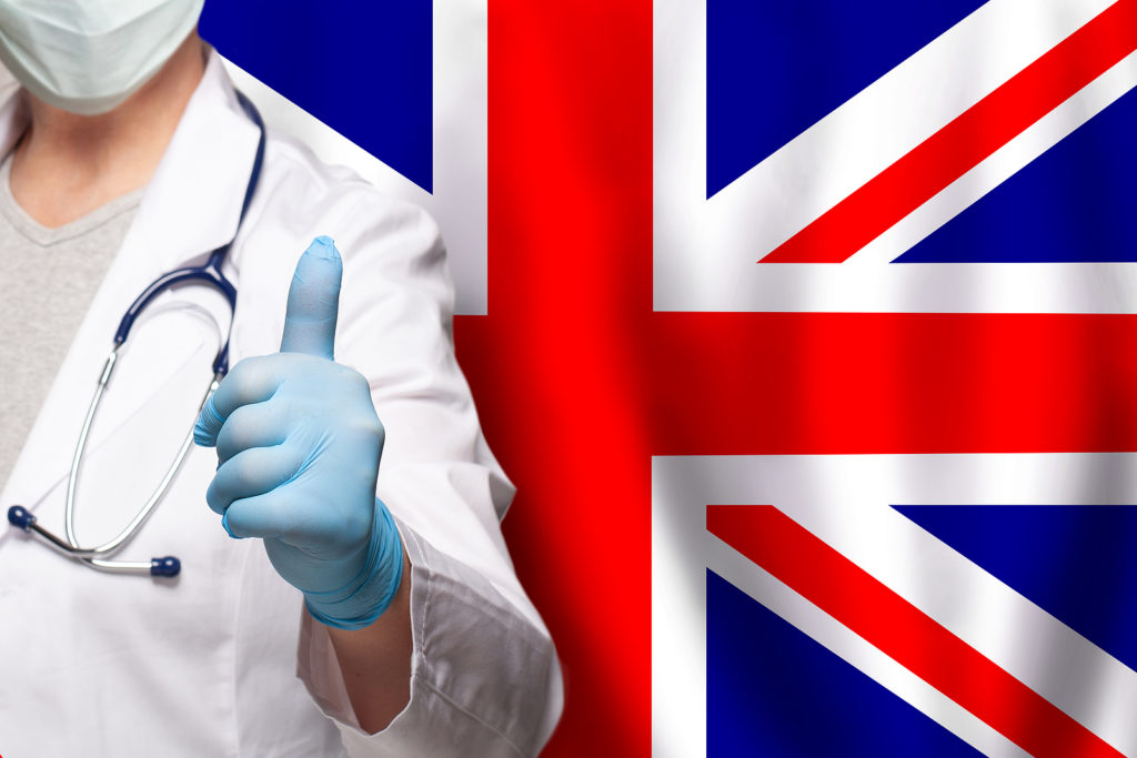 Uk Doctor's Hand Showing Thumb Up Positive Gesture On Flag Of Un