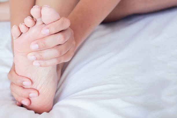 Closeup of pregnant woman hands doing foot massage.